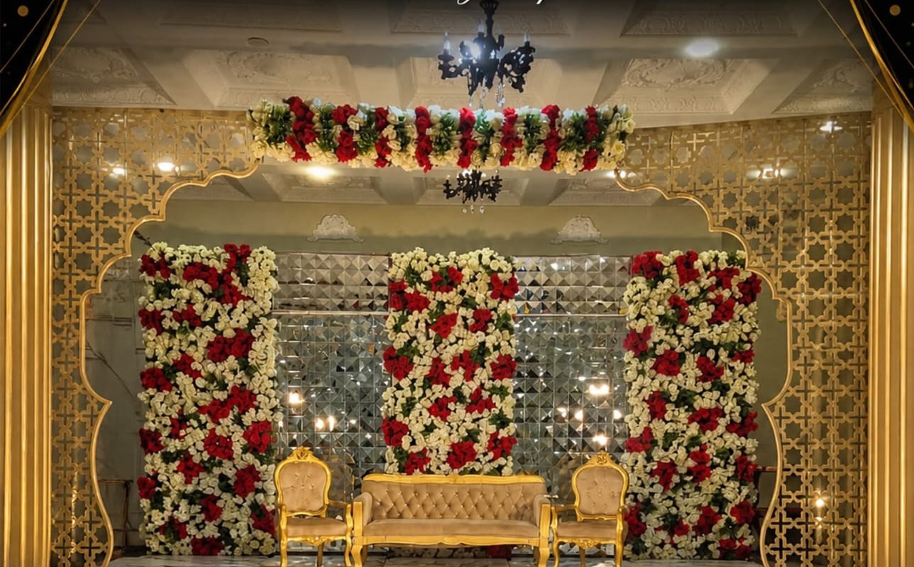 Signature arch stage with mirror-and-floral backdrop